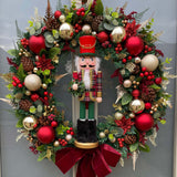 Decorative Christmas wreath with a nutcracker figure, red ribbons, and festive ornaments on a door.