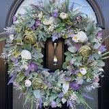 Large 60cm artificial flower wreath in lavender, green and white with flowers such as ranunculus, hydrangea, hops, lavender and lambs ear and other flocked foliage with accents of silver fern.
