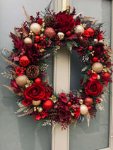 Extra large luxury Christmas wreath with red and gold accents, featuring roses, baubles, and pinecones on a green background.