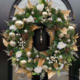 A large and extra full natural looking pine spruce base with accents of gold, baubles in gold and cream, ivory roses and berries and gold pinecones.