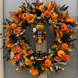 Halloween-themed wreath with pumpkins, flowers, and a pumpkin nutcracker figure in the centre 