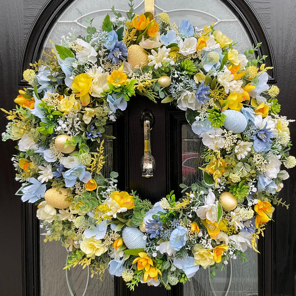 Luxury 60cm handmade pastel spring wreath with yellow, with abundance of blue cosmos and faux pastel eggs, perfect for Easter decor.