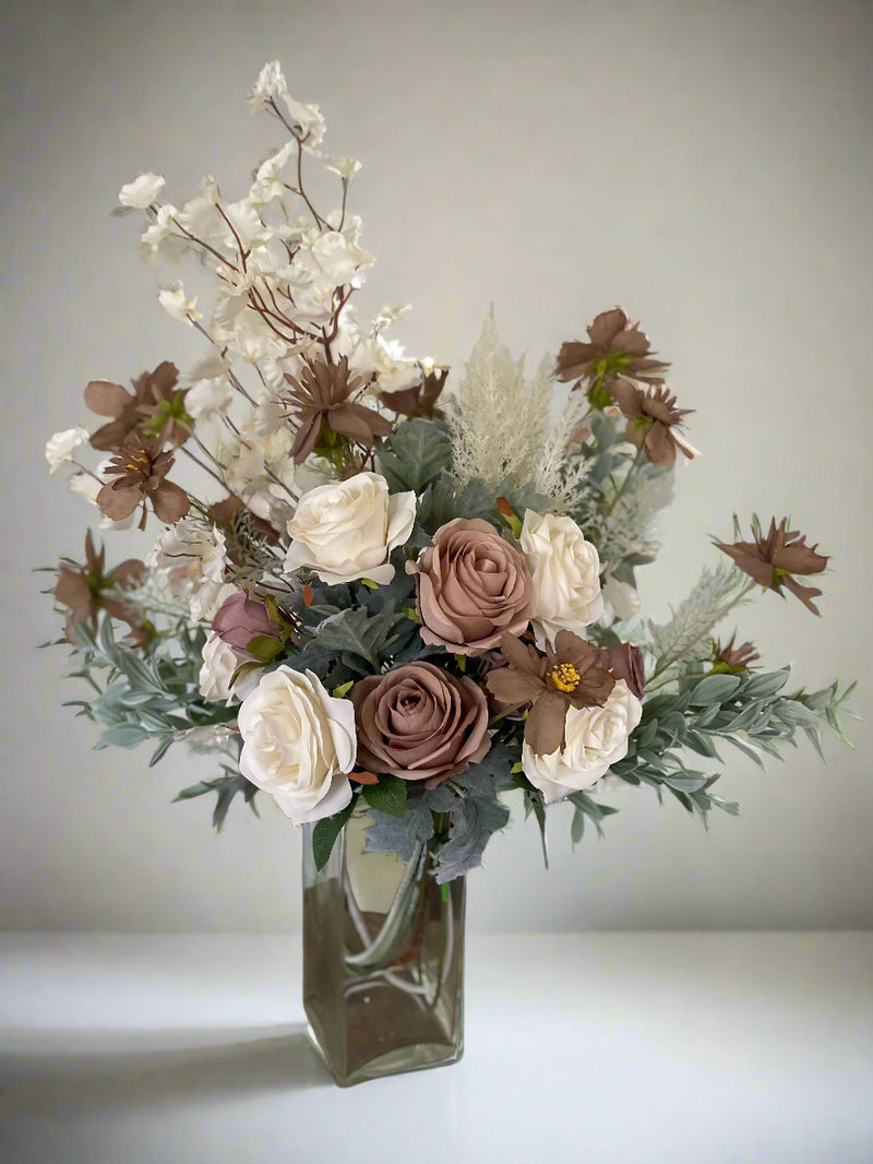 An extra large artificial flower arrangement featuring muted tones of mocha, coffee and vanilla. Frilly cosmos, lambs ear and flocked leaves create the whimsical branch background to the vanilla and coffee roses in the centre. 